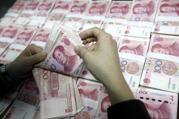 A Chinese clerk counts RMB (renminbi) yuan banknotes at a bank in Huaibei city. (Photo: AAP)