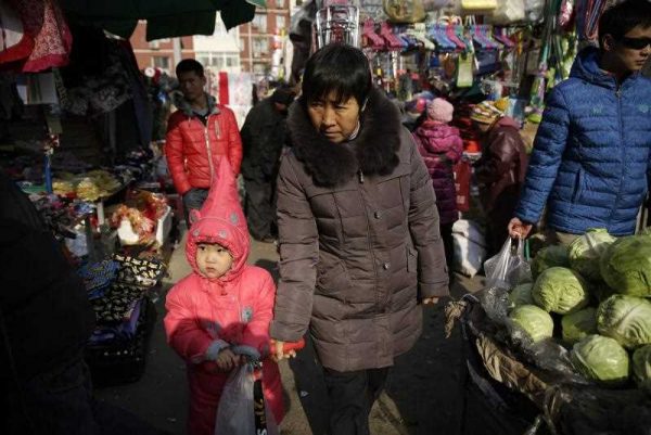 Chinese people shop in a market in Beijing, China, 14 January 2016. (Photo: AAP)