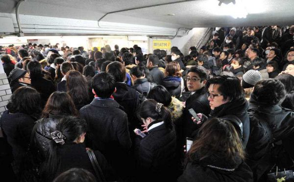 A crowd forms at the Keio Line’s Chitose-Karasuyama Station in Setagaya Ward, Tokyo, 18 January 2016. (Photo: AAP).