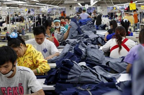 Laotian textile garment factory workers at work sewing clothes for export to Germany and other European markets, in the nation's largest textile factory located on the outskirts of Vientiane, Laos. (Photo: AAP).