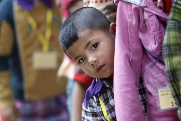 A child looks as he queues for aid donations at a monastery which is being set up as a temporary refugee camp in KyaukMe, northern Shan State, Myanmar, 20 February 2016. (Photo: AAP).