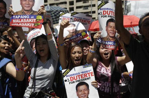 Supporters of Philippine presidential candidate Rodrigo Duterte shouts slogans as they wait outside a bank in Pasig, east of Manila, Philippines on Monday, 2 May 2016. (Photo: AAP).