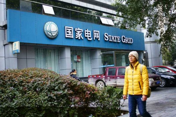 A pedestrian walks past a branch of State Grid Corporation of China in Yichang city, central China's Hubei province, 11 January 2016. (Photo: AAP).