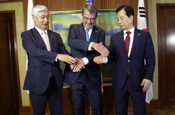 US Defense Secretary Ash Carter, joins his hands with Japan's Defense Minister Gen Nakatani, and South Korea's Defense Minister Han Min Koo during their trilateral meeting on the sidelines of the 15th International Institute for Strategic Studies Shangri-la Dialogue in Singapore. (Photo AAP).