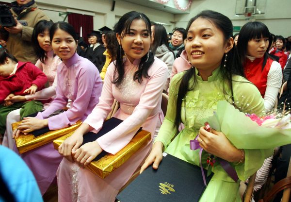 Migrant wives, dressed in the apparel of their native countries, after graduating from a Korean-language course. (Photo: AAP).