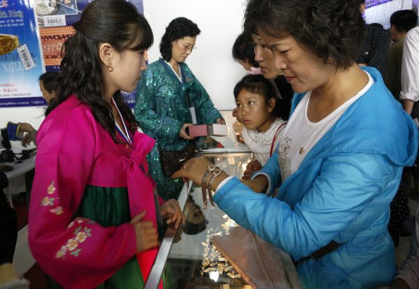 A North Korean woman looks at gold watches at a trade fair booth in Pyongyang, North Korea, 25 September 2012. (Photo: AAP).