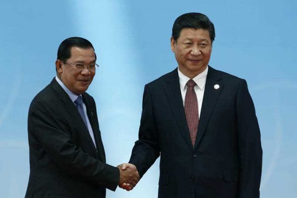 Hun Sen and Xi Jinping meet in Shanghai in May 2014. (Photo: AAP)