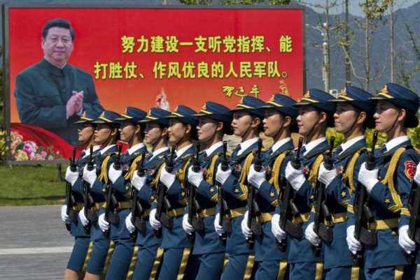 Soldiers march past a billboard of Chinese President Xi Jinping at a barracks near Beijing, 22 August 2015. (Photo: AAP)