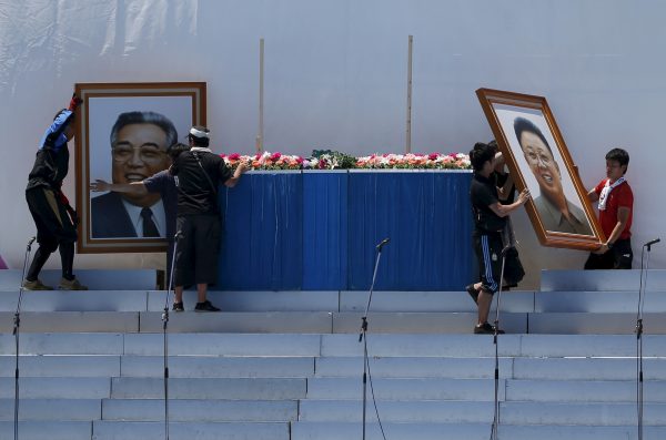 Members of the pro-Pyongyang General Association of Korean Residents in Japan move portraits of North Korea's late founder Kim Il Sung and late leader Kim Jong Il from the stage during a celebration ceremony to mark the 60th anniversary of the establishment of the association in Tokyo, 31 May 2015. (Photo: Reuters).