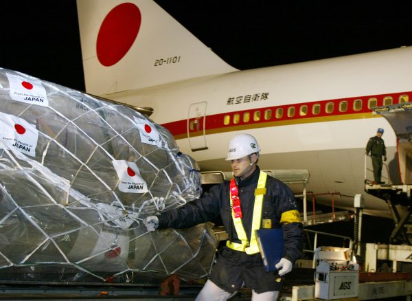 Airport workers prepare to load a shipment of relief supplies into a Japanese government plane at Narita Airport, Japan, 30 March 2003. (Photo: Reuters).