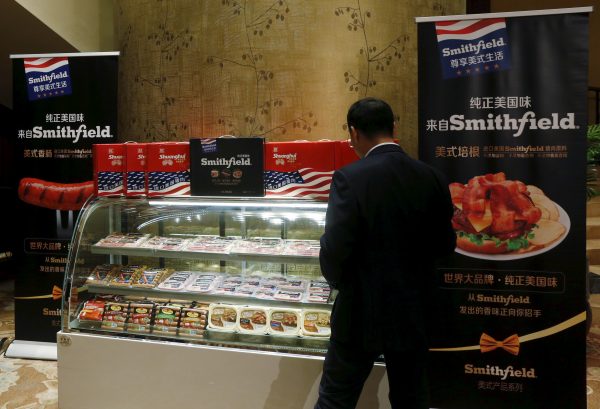 A man looks at products of Smithfield, acquired by Shuanghui, on display at a news conference on the company's annual results in Hong Kong, China, 29 March 2016. (Photo: Reuters).