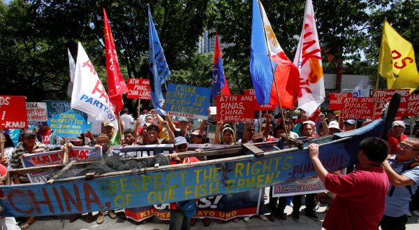 Demonstrators display a part of a fishing boat with anti-China protest signs during a rally by different activist groups over the South China Sea disputes, outside the Chinese Consulate in Makati City, Philippines, 12 July 2016. (Photo: Reuters).