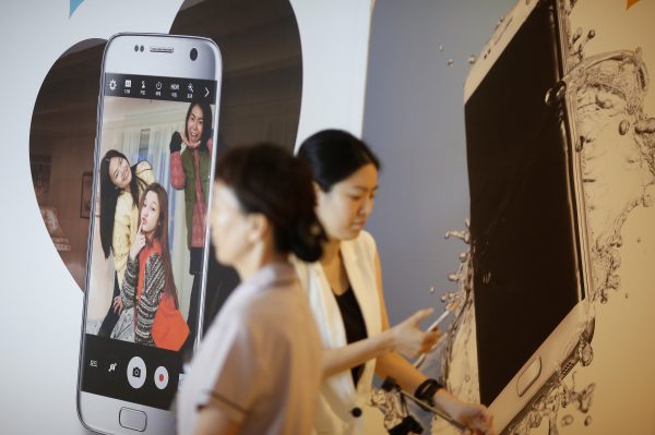 Women walk past an advertisement promoting a Samsung Electronics smartphone at its headquarters in Seoul, South Korea. (Photo: Reuters).