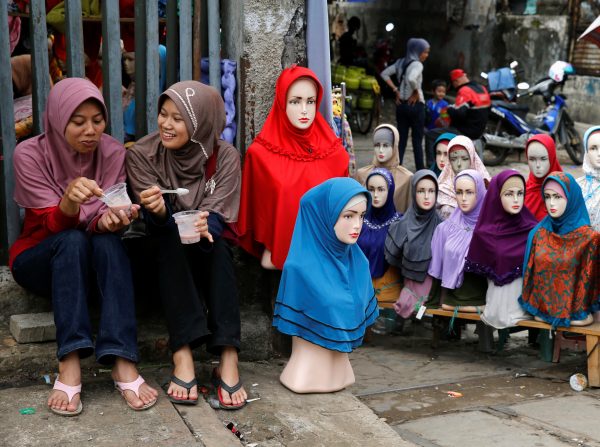 Girls sit near mannequins displaying hijabs for sale at Tanah Abang market in Jakarta. (Photo: Reuters).