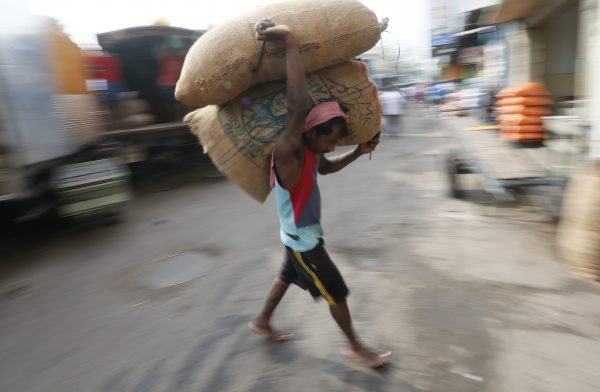 A worker carries a sack of rice at a market in Colombo, 29 January 2016. (Photo: Reuters).