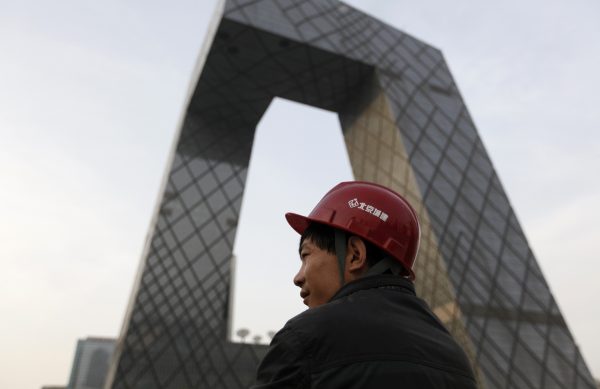 A worker stands at a construction site next to the China Central Television (CCTV) building in Beijing, China, 14 April 2013. (Photo: Reuters).
