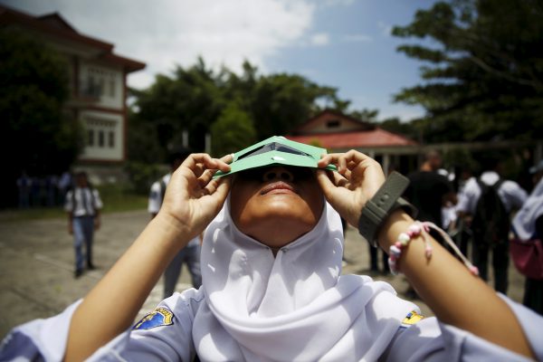 A student tests a self-made filter and looks at the sun at a high school in Ternate island, Indonesia. (Photo: Reuters/Beawiharta).