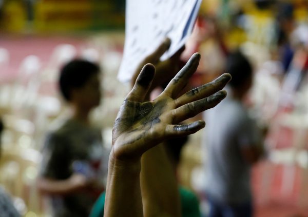 A drug user raises his ink-smeared hand after he surrendered to local government officials to take part in a government campaign against drugs in Tanauan Batangas, Philippines, 18 July 2016. (Photo: Reuters/Erik De Castro).