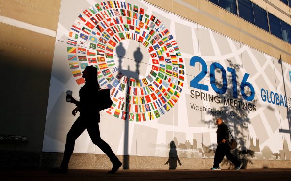 A woman walks past the International Monetary Fund headquarters during the IMF and World Bank Spring Meetings in Washington, April 16, 2016. (Photo: Reuters/Kevin Lamarque).