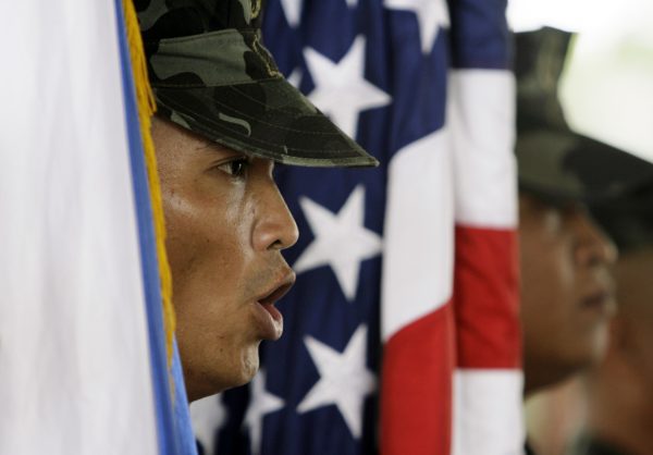 Marines from the Armed Forces of the Philippines carry flags from the Philippines and the US during the opening ceremony of the annual joint military exercise PHIBLEX, inside Marine headquarters in Manila, Philippines, 16 October 2007. (Photo: Reuters/Darren Whiteside).