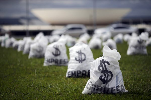 Replica of bags full of money can be seen in front of the National Congress during a protest symbolising the donations of private companies for election campaigns, Brazil, 24 March 2015. (Photo: Reuters/Ueslei Marcelino).