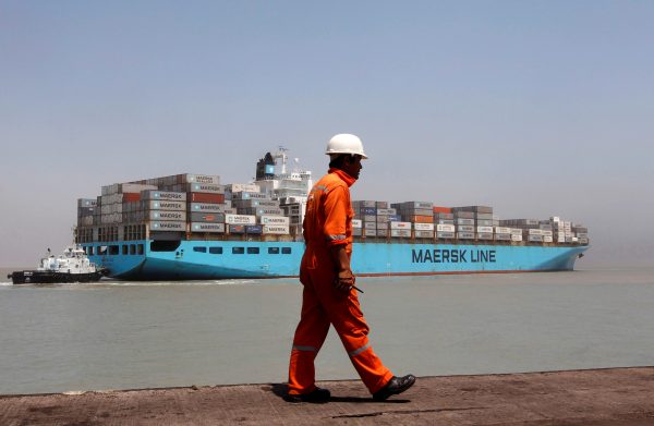 A worker walks past a container ship at Mundra Port in the western Indian state of Gujarat, 1 April 2014. (Photo: Reuters/Amit Dave).