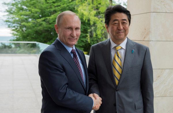 Russian President Vladimir Putin shakes hands with Japanese Prime Minister Shinzo Abe during a meeting at the Bocharov Ruchei state residence in Sochi, Russia, 6 May 2016. (Photo: Reuters)
