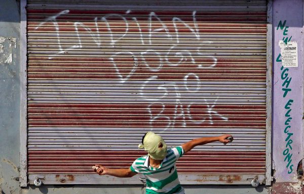 A demonstrator hurls a stone at the Indian policemen during an anti-India protest in Srinagar, 7 October, 2016. (Photo: Reuters/Danish Ismail).