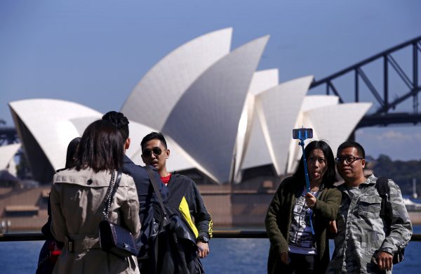 Chinese tourists taking pictures of themselves as they pose in front of the Sydney Opera House in Sydney, Australia. (Photo: Reuters/David Gray).