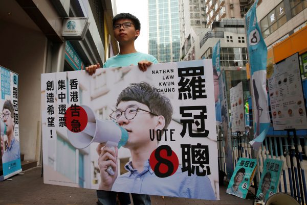 Student activist Joshua Wong holds a banner of Nathan Law, candidate from Demosisto on election day for the Legislative Council in Hong Kong, China, 4 September 2016. (Photo: Reuters/Tyrone Siu).