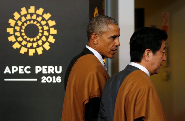 Wearing Peruvian shawls, US President Barack Obama and Japanese Prime Minister Shinzo Abe talk after taking part in a family photo at the APEC Summit in Lima, Peru, 20 November 2016. (Photo: Reuters/Kevin Lamarque).