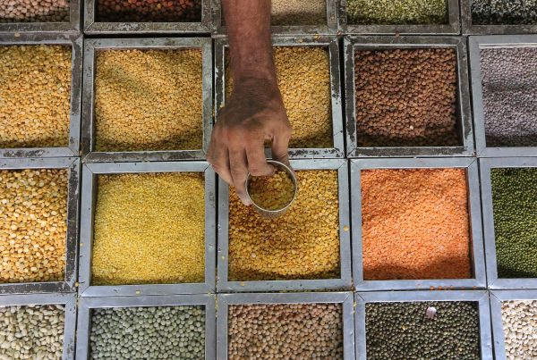 An employee collects lentils from a container inside a grocery store at a residential area in Mumbai, India, 11 May 2016. (Photo: Reuters/Shailesh Andrade).