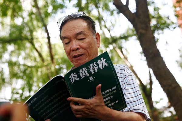 Wang Yanjun, former vice editor-in-chief of the liberal magazine Yanhuang Chunqiu, also known as China Through the Ages, holds an issue of the magazine as he speaks to the media outside the Chaoyang District Court in Beijing, China, 16 August 2016. (Photo: Reuters/Thomas Peter).