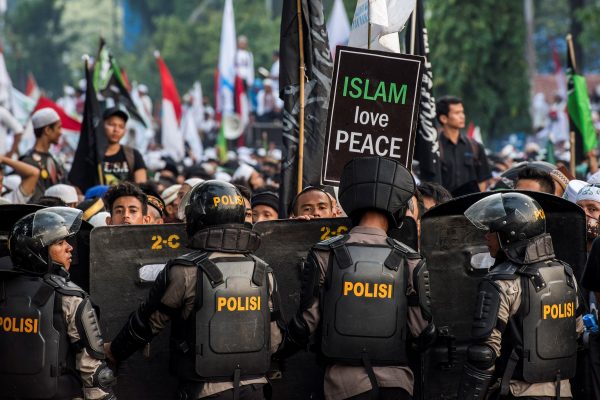 Anti-riot policemen stand guard as Muslim hardline protesters attend a protest against Jakarta's incumbent governor Basuki (Ahok) Tjahaja Purnama, an ethnic Chinese Christian running in the upcoming election, in Jakarta, Indonesia, 4 November 2016. (Photo: Reuters/Antara Foto).
