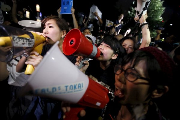 Protesters reacts after Japan's parliament approve the security bills at a rally against Japan's Prime Minister Shinzo Abe's security bill and his administration in front of the parliament in Tokyo, 19 September 2015. The upper house of Japan's parliament approved security bills on Saturday clearing the way for a policy shift that could allow troops to fight overseas for the first time since 1945, a milestone for Prime Minister Shinzo Abe's agenda of loosening the limits of the pacifist constitution on the military. (Photo: Reuters/Issei Kato).