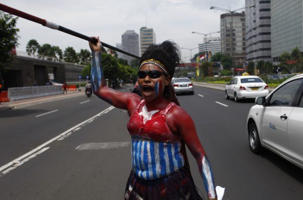 A West Papuan woman dances with her spear during a protest (Photo: Reuters).