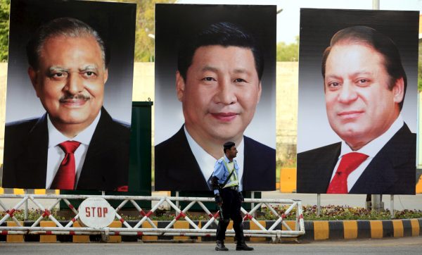 A policeman stands guard next to giant portraits of Pakistan’s President Mamnoon Hussain, China’s President Xi Jinping, and Pakistan’s Prime Minister Nawaz Sharif, displayed along a road ahead of Xi’s visit to Islamabad, 19 April 2015. (Photo: Reuters/Faisal Mahmood).