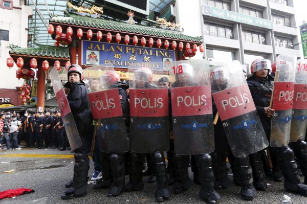 Riot police protect the entrance to Chinatown from ‘Red Shirt’ demonstrators during a rally to celebrate Malaysia Day and to counter a massive protest held over two days last month that called for Prime Minister Najib Razak's resignation over a graft scandal, in Malaysia's capital city of Kuala Lumpur 16 September 2015 (Photo: Reuters/Olivia Harris).