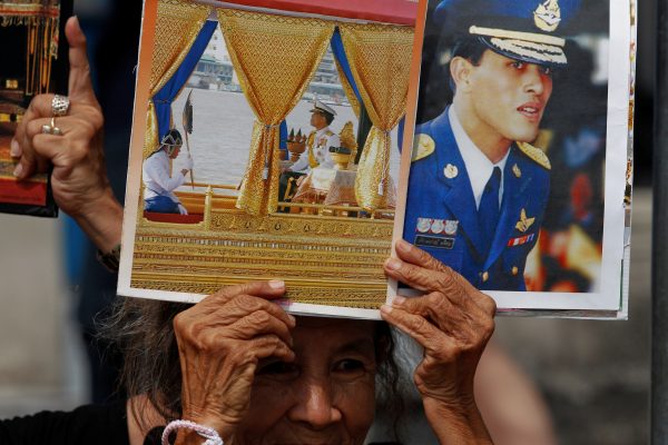 A well-wisher holds up pictures of Thailand's new King Maha Vajiralongkorn Bodindradebayavarangkun before he arrives at the Grand Palace in Bangkok, Thailand, 2 December 2016. (Photo: Reuters/Chaiwat Subprasom).