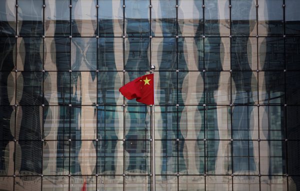 A Chinese national flag flutters at the headquarters of a commercial bank on a financial street near the headquarters of the People’s Bank of China, China’s central bank, in central Beijing, 24 November 2014. (Photo: Reuters/Kim Kyung-Hoon).