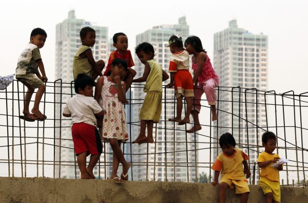 Children play at a flood canal construction site in Jakarta (Photo: Reuters).