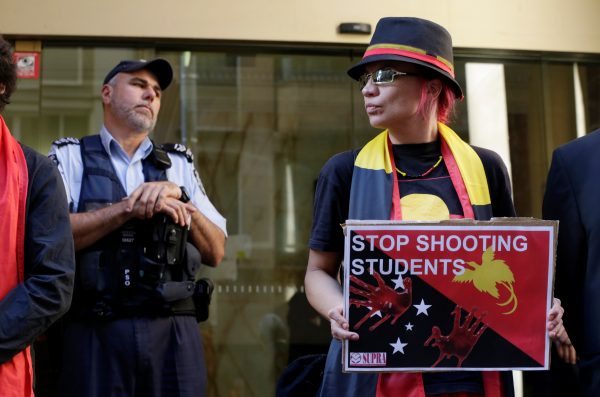 An Australian Federal Policeman guards the entrance during a demonstration against police violence earlier in the week against university students in Port Moresby, outside the Papua New Guinea Consulate in Sydney, Australia, 10 June 2016. (Photo: Reuters/Jason Reed)