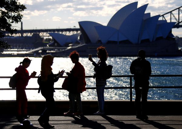 Chinese and Malaysian tourists take photographs of the Sydney Opera House, Sydney Harbour, Australia. (Photo: Reuters/David Gray).