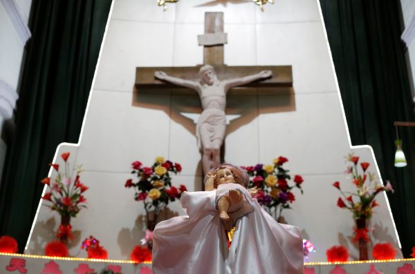 A priest holds an effigy of baby Jesus during a Christmas eve mass at a Catholic church on the outskirts of Taiyuan, North China's Shanxi province, 24 December, 2016. (Photo: Reuters/Jason Lee).