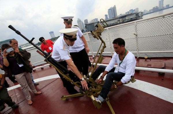 Members of the Russian Navy show to a visitor how to operate a 12.7mm anti-aircraft machine gun during a public tour onboard the Russian Navy vessel Admiral Tributs, a large anti-submarine vessel, docked at the South Harbor, Port Area, in Metro Manila, Philippines 5 January 2017 (Photo: Reuters/Romeo Ranoco)