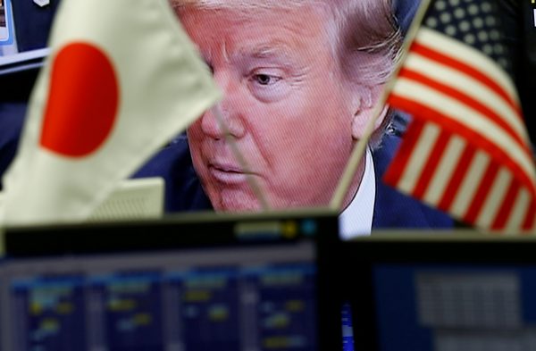 A TV monitor showing US President Donald Trump is seen through the US and Japan national flags (Photo: Reuters/Kim Kyung-Hoon).