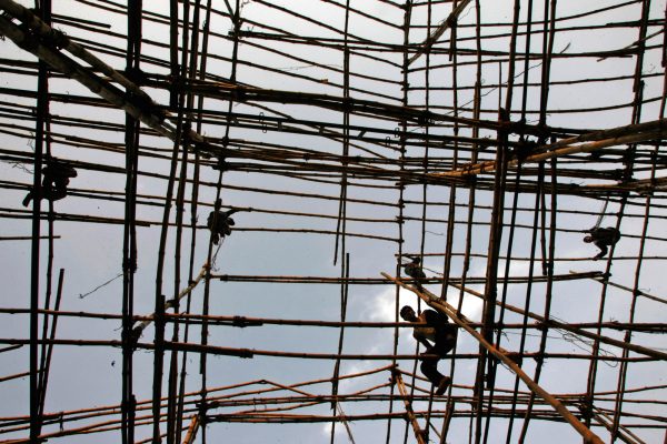 Workers tie bamboo to erect a temporary shade for shops in New Delhi (Photo: Reuters/Kamal Kishore).