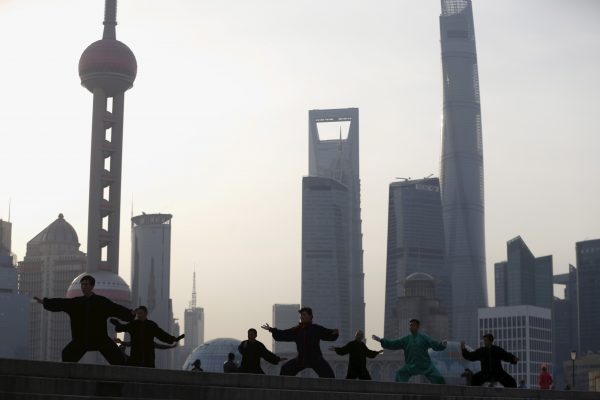 People perform Tai Chi on the Bund in front of the financial district of Pudong in Shanghai, China (Photo: Reuters/Aly Song).