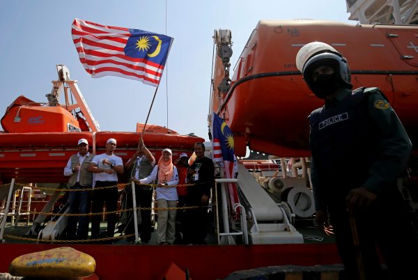 Volunteers on the Malaysian aid ship Nautical Aliya wave the Malaysian flag as they provide relief for Rohingya refugees in Chittagong, Bangladesh, 14 February, 2017 (Photo: Reuters/Mohammad Ponir Hossain).