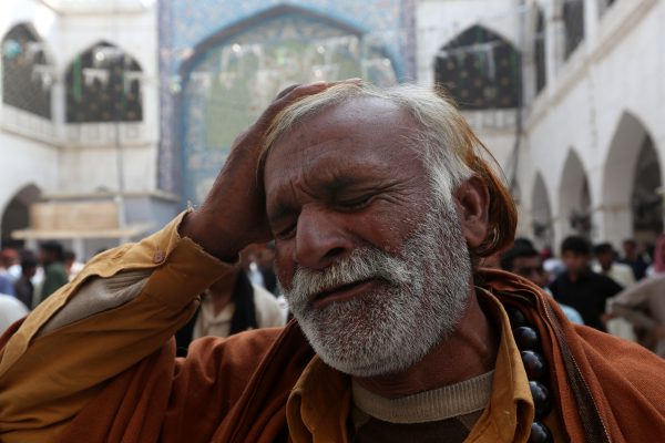 A man beats his head as he mourns the death of a relative who was killed in a suicide blast at the tomb of Sufi saint Syed Usman Marwandi, also known as the Lal Shahbaz Qalandar shrine in Sehwan Sharif, Pakistan's southern Sindh province, 17 February 2017. (Photo: Reuters/Akhtar Soomro).
